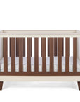 The Como cot bed in cashmere and rich walnut, featuring wooden slate slats in a sturdy, modern frame with a mattress.