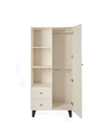 A tall cream-colored nursery wardrobe with a high-shelf design, two drawers underneath, and a single open door showcasing two hanging rails inside. It stands on short, angled dark legs against a plain white background.