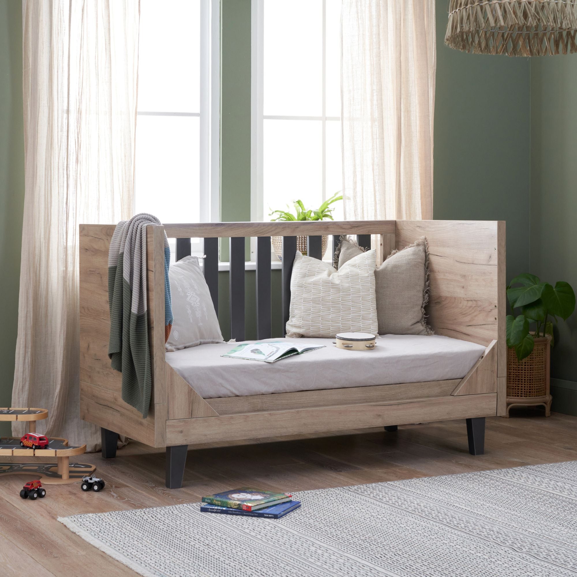 Como Cot Bed in oak and grey on the sofa mode in a calm nursery.