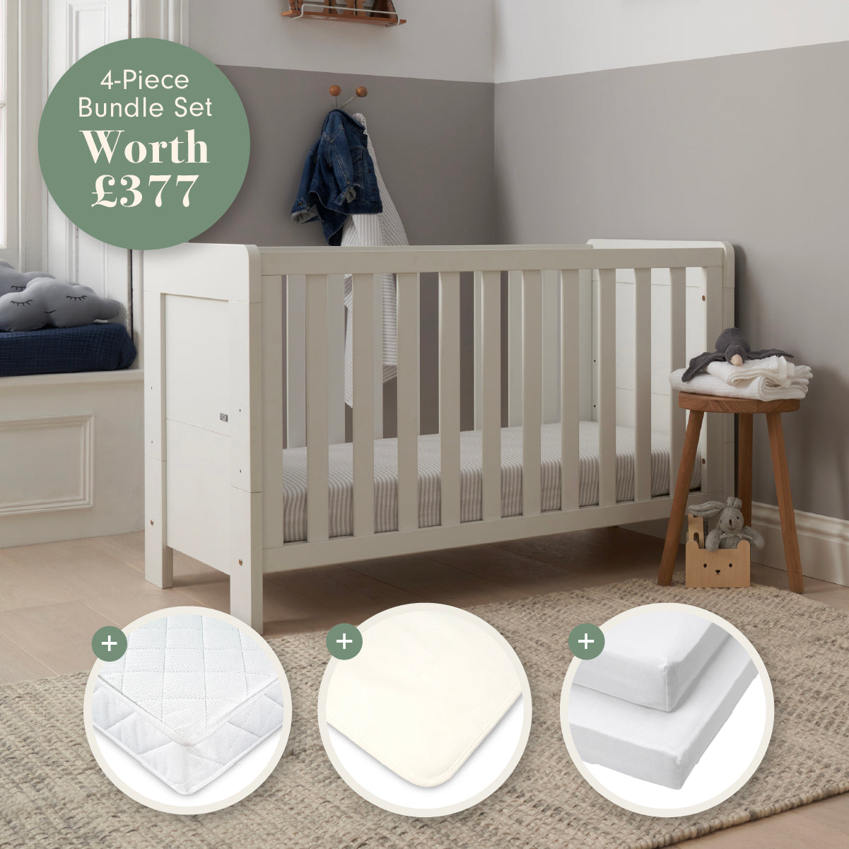 Alba Mini Cot Bed in white in a room with a mattress and baby bedding products displayed below.
