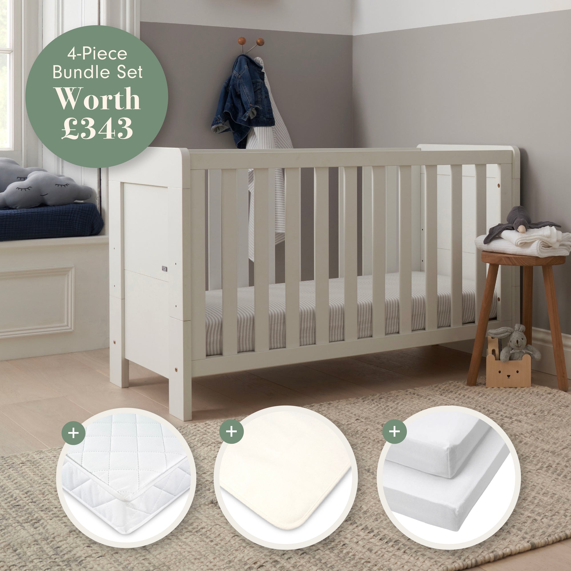 Alba Mini Cot Bed in white in a room with baby bedding products displayed below.