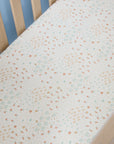 Farm-patterned cot bed sheet on a wooden cot with a light blue wall background