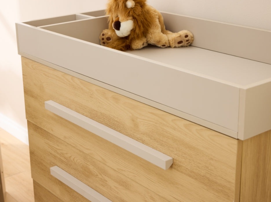 Close-up of Hallee chest changer in mushroom and golden oak showing removable changing top and smooth painted surround.