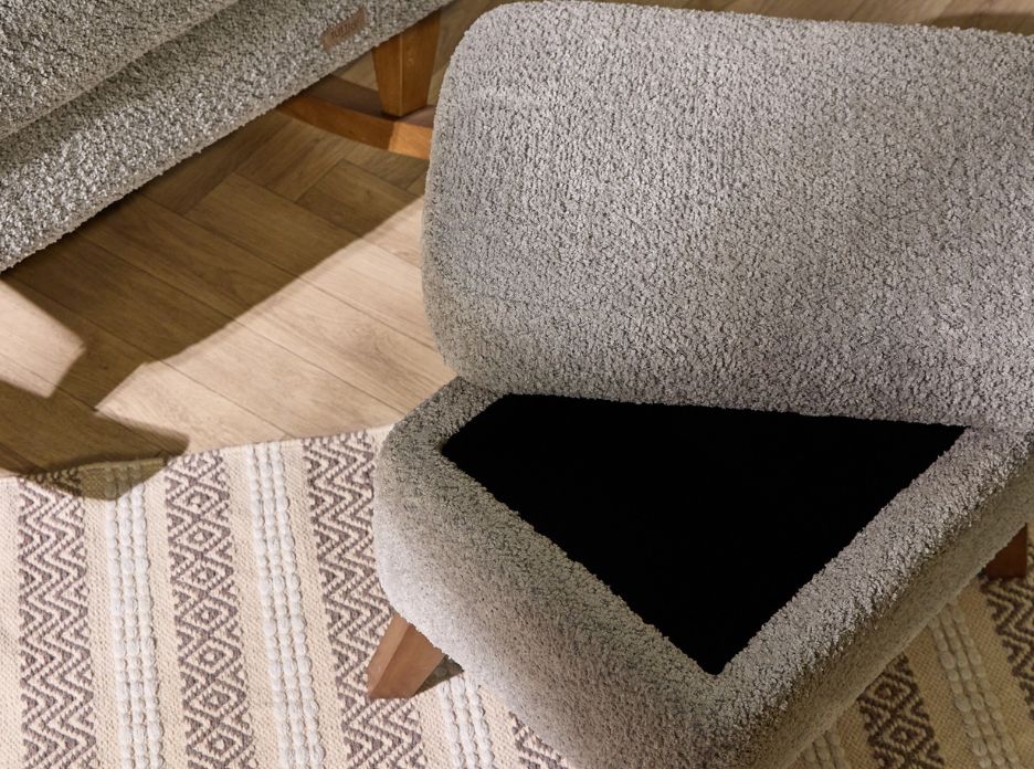 Close-up of the Harper footstool in cloud grey with open lid, revealing internal storage and boucle texture against a wooden floor.