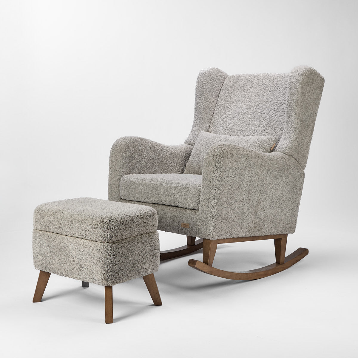 Angled cutout of the Harper Wingback chair and footstool in cloud grey boucle, showing deep cushioning and curved wooden legs.