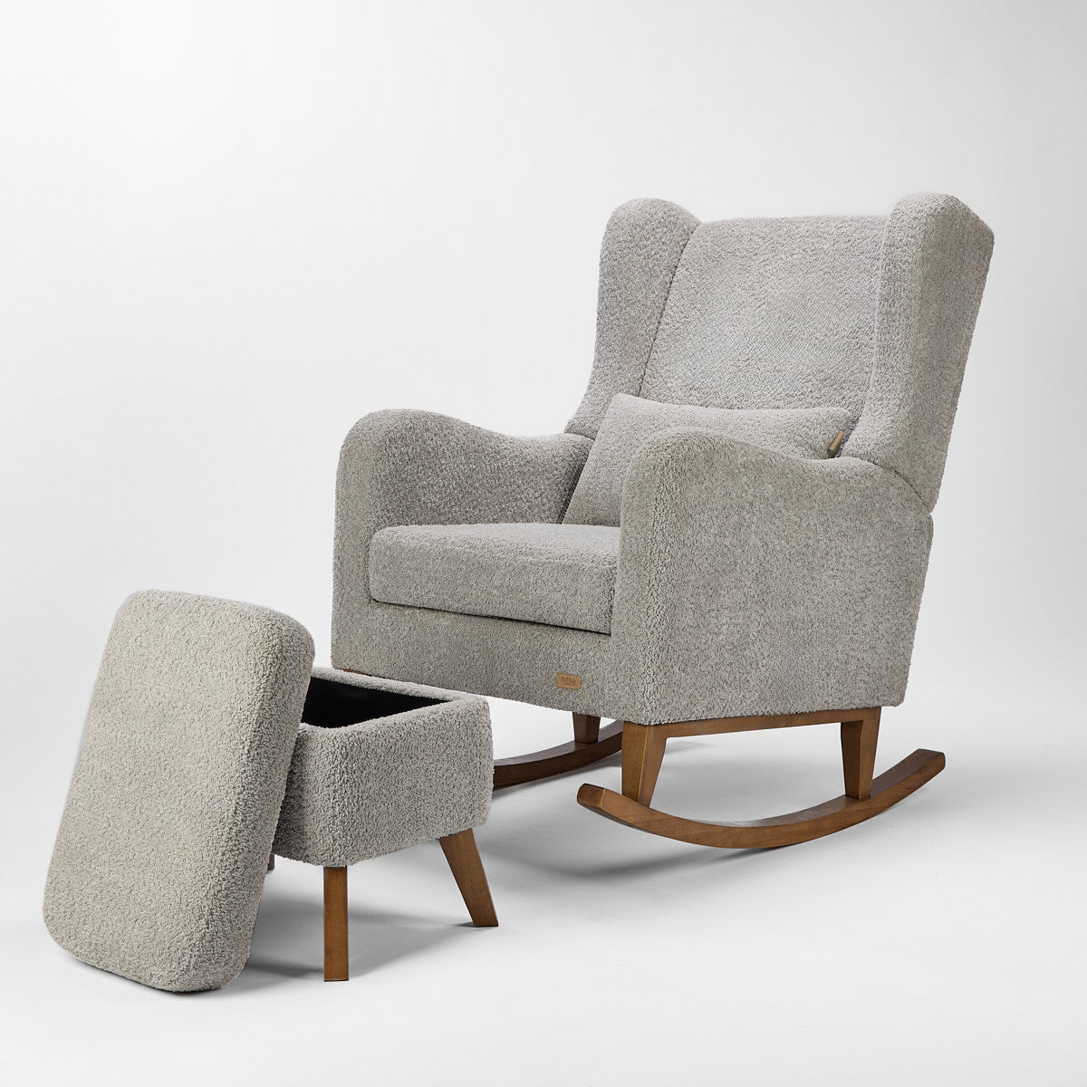 Angled cutout of the Harper Wingback chair and footstool in cloud grey boucle, showing deep cushioning and curved wooden legs.
