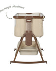 An infographic of a bedside crib with a cream quilted fabric and brown wooden frame and legs, shown on a white background. The text points to a '6 step height adjustment' highlighting the height adjustment mechanism.