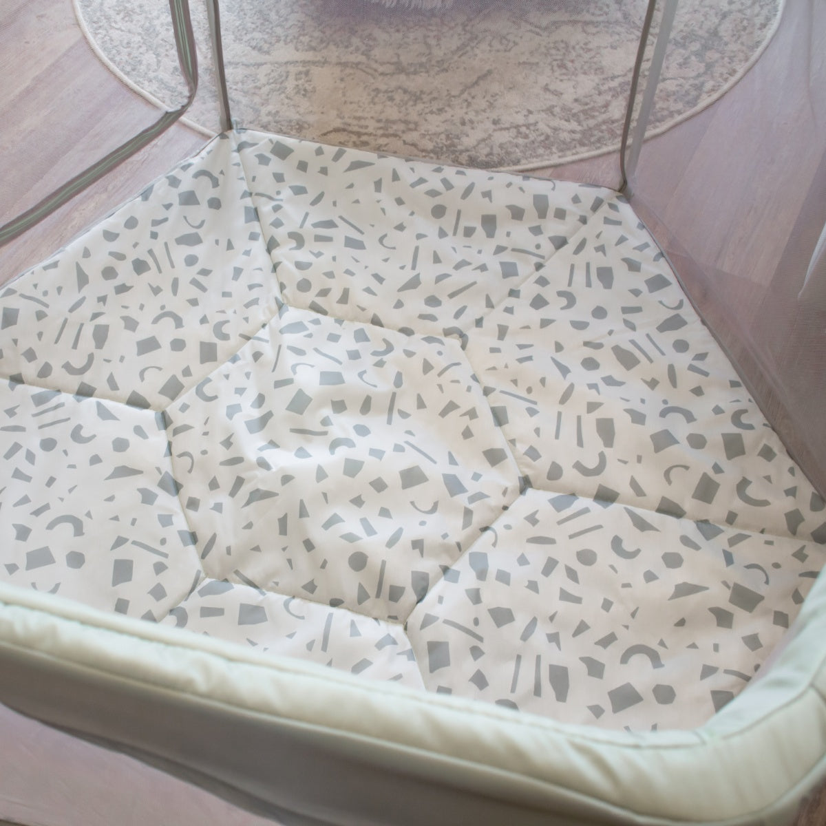 Overhead view of the Hexa playpen in Leaf Terrazzo with softly padded terrazzo-patterned base and breathable mesh panels