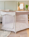 Full room view of the Hexa Playpen in mushroom terrazzo, with breathable mesh sides and zip-down opening in a calm neutral setting