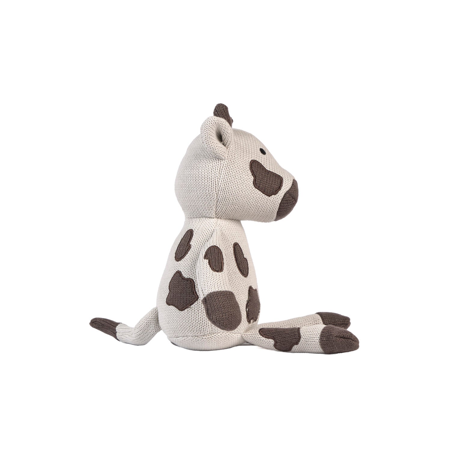 Side angle of plush Clemi cow toy on a white background.