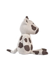 Side angle of plush Clemi cow toy on a white background.