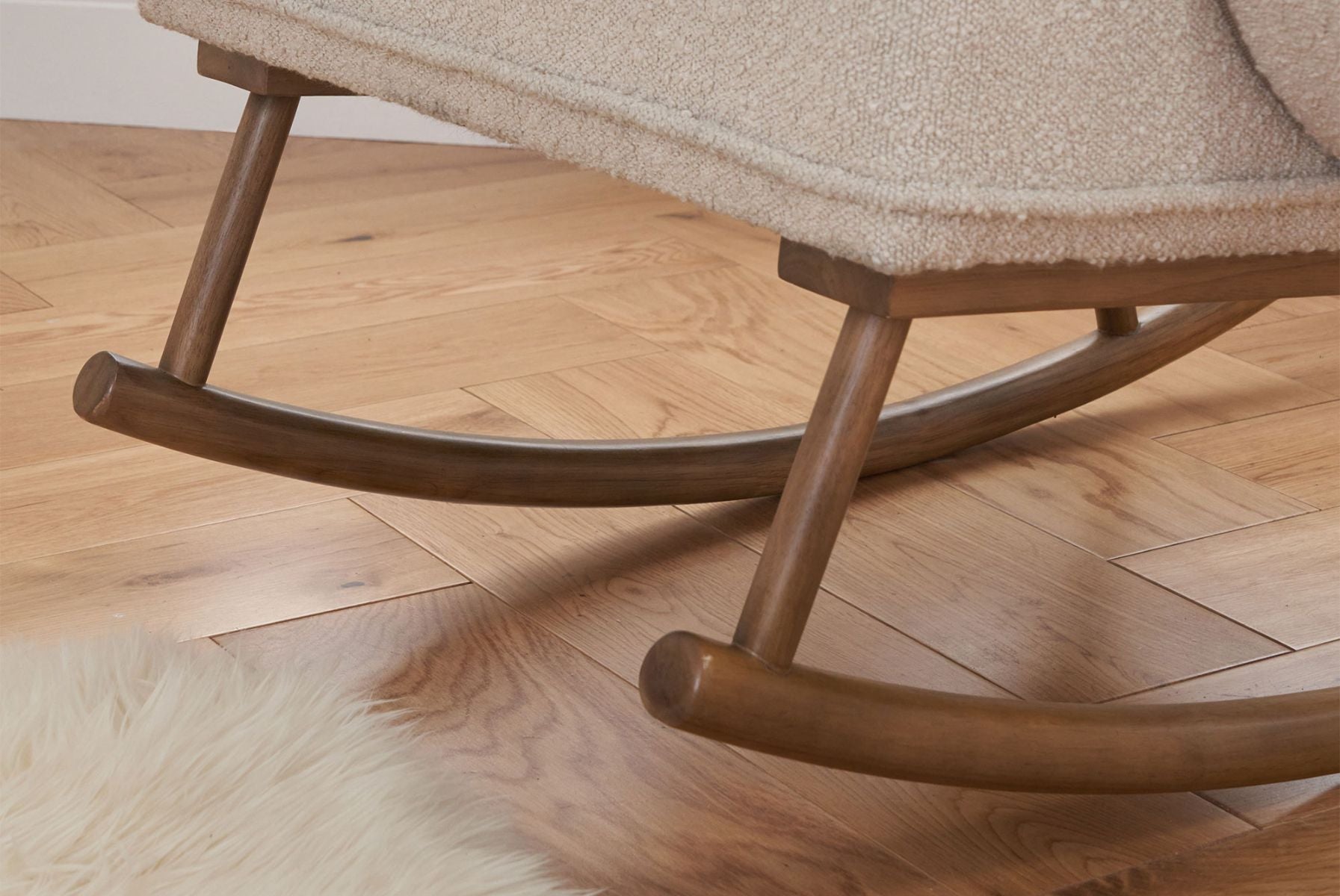 Close-up of the Micah rocking chair’s smooth wooden rocker base, highlighting sturdy craftsmanship and gentle rocking motion