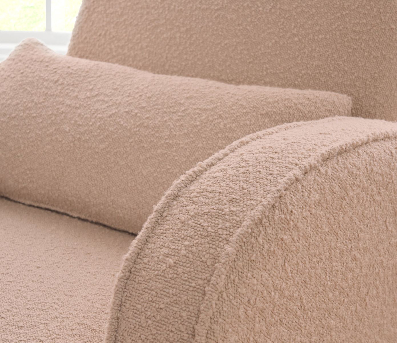 Close-up of the Micah rocking chair in boucle blush, highlighting the soft textured upholstery and gently rounded, cushioned armrest