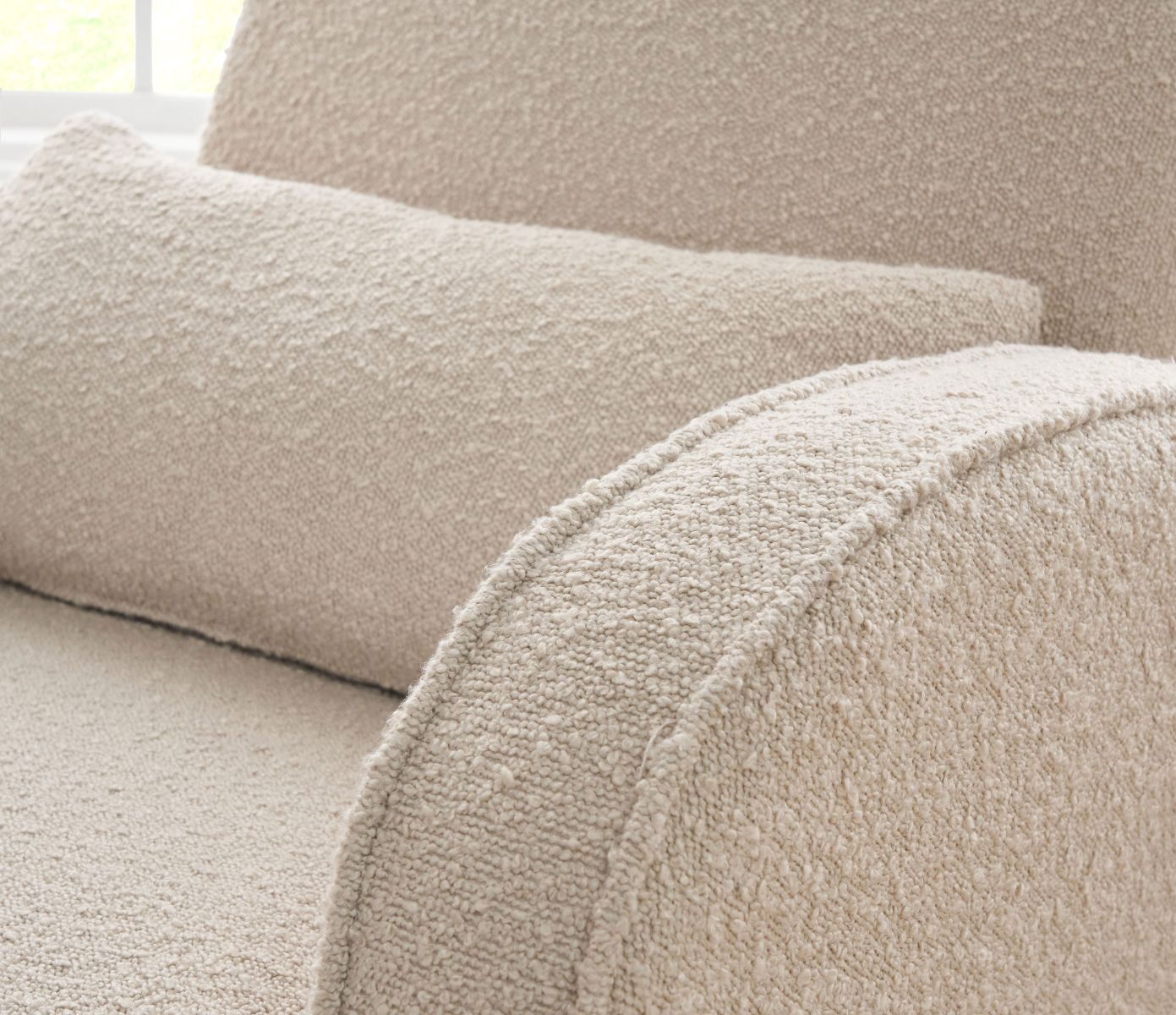 Detailed view of the Micah rocking chair in boucle biscuit, showcasing textured upholstery, rounded arms, and cushioned support