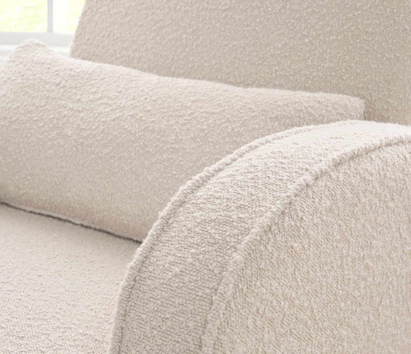 Close-up detail of the Micah rocking chair showing the soft bouclé fabric, rounded design details, and cushioned seat.