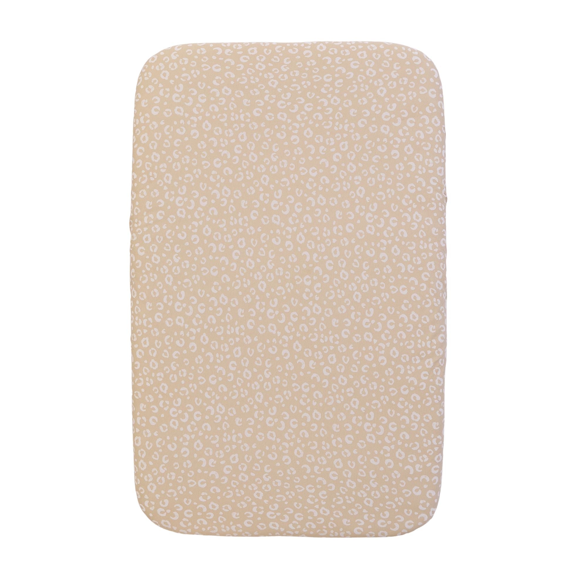 A bedside crib fitted sheets with a leopard inspired print, on a white background