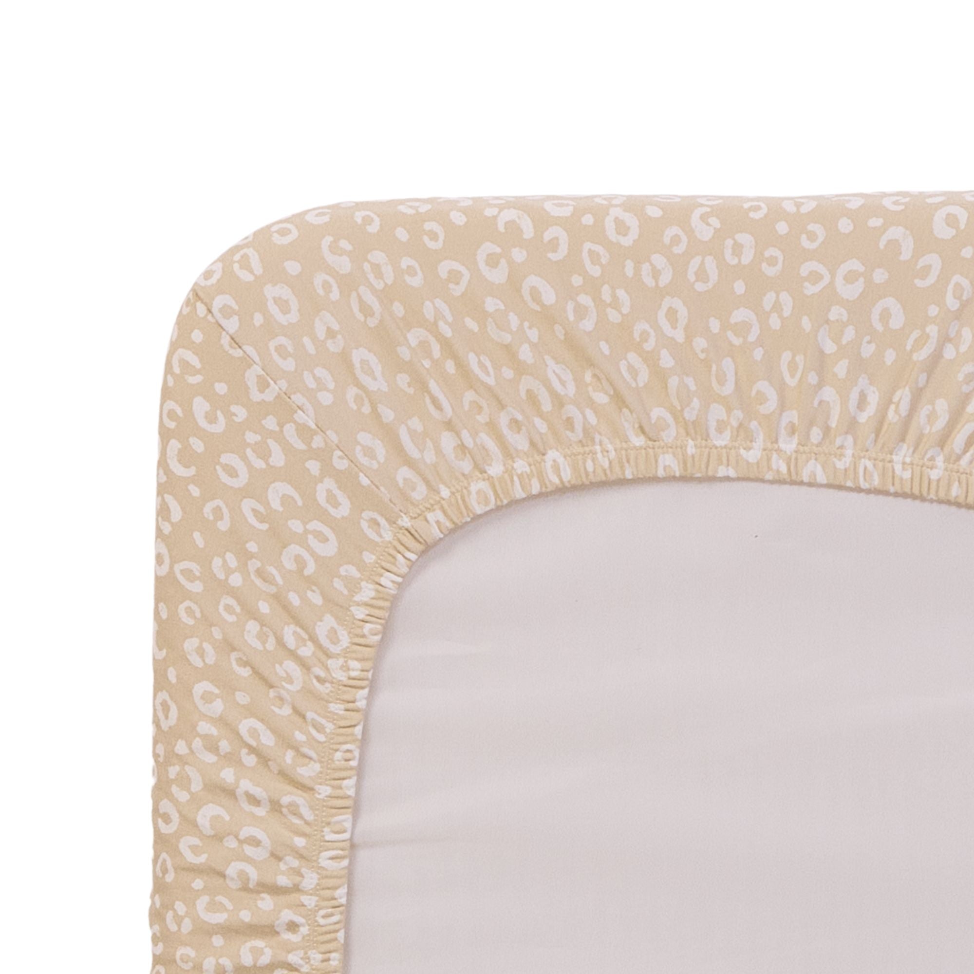 Close-up of a beige and white leopard print fitted sheet on a mattress.