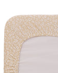 Close-up of a beige and white leopard print fitted sheet on a mattress.