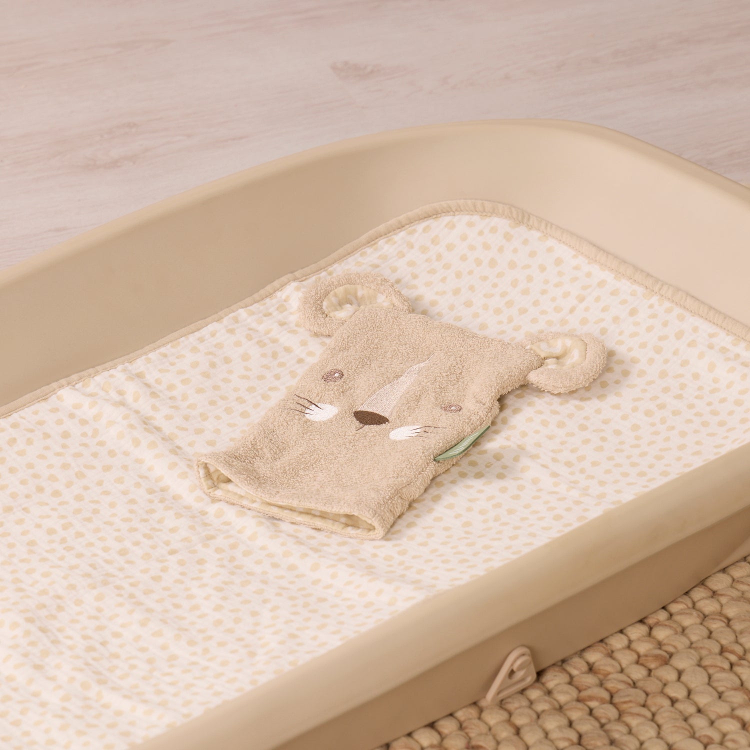 Wash mitt with a leopard design on a changing table with a neutral background