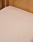 Neutral speckled love cats cot bed fitted sheet styled on wooden cot mattress, highlighting snug fit and soft breathable cotton fabric.