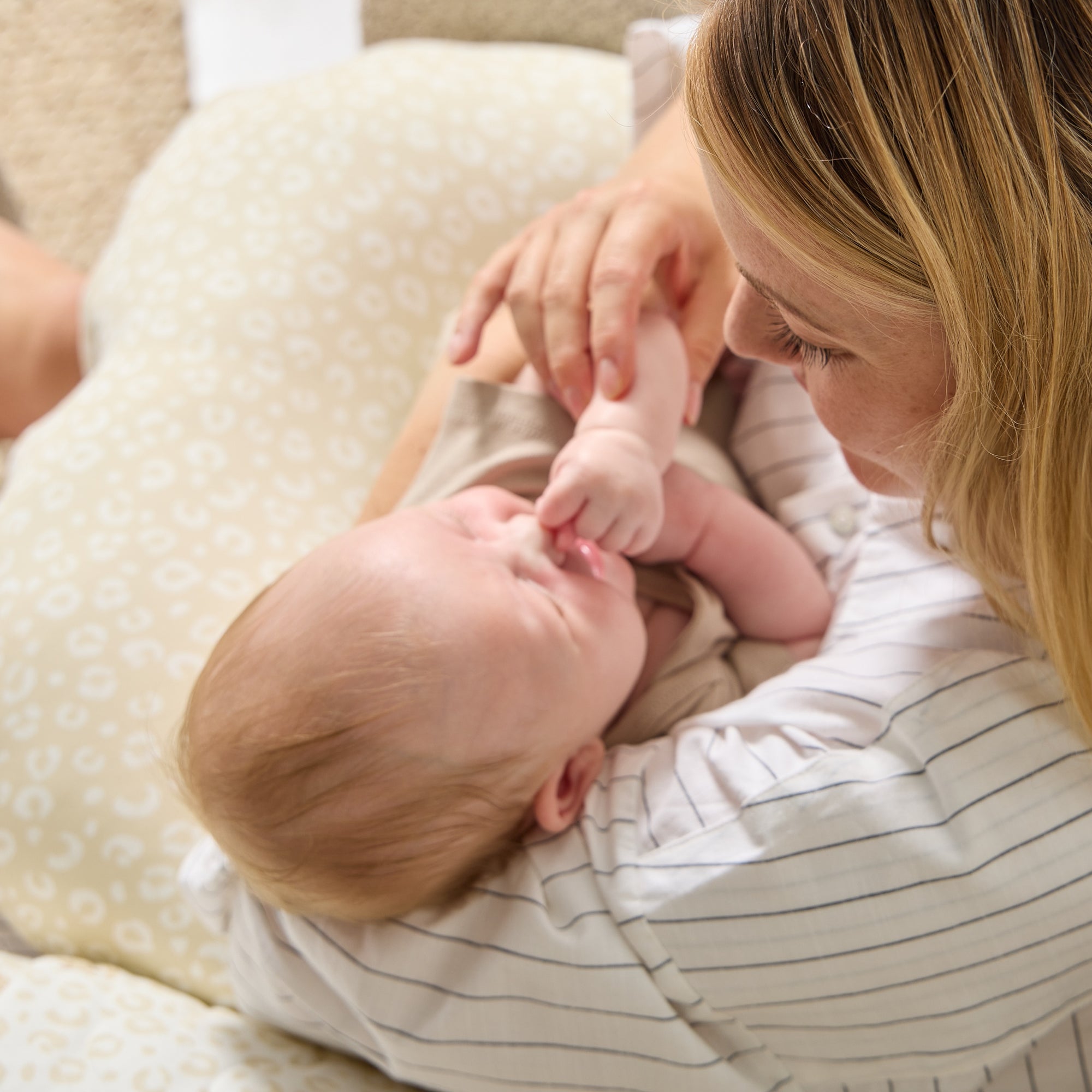 Overhead view of mum holding baby on the Love Cats feeding pillow, highlighting secure support and soft, cushioned design.