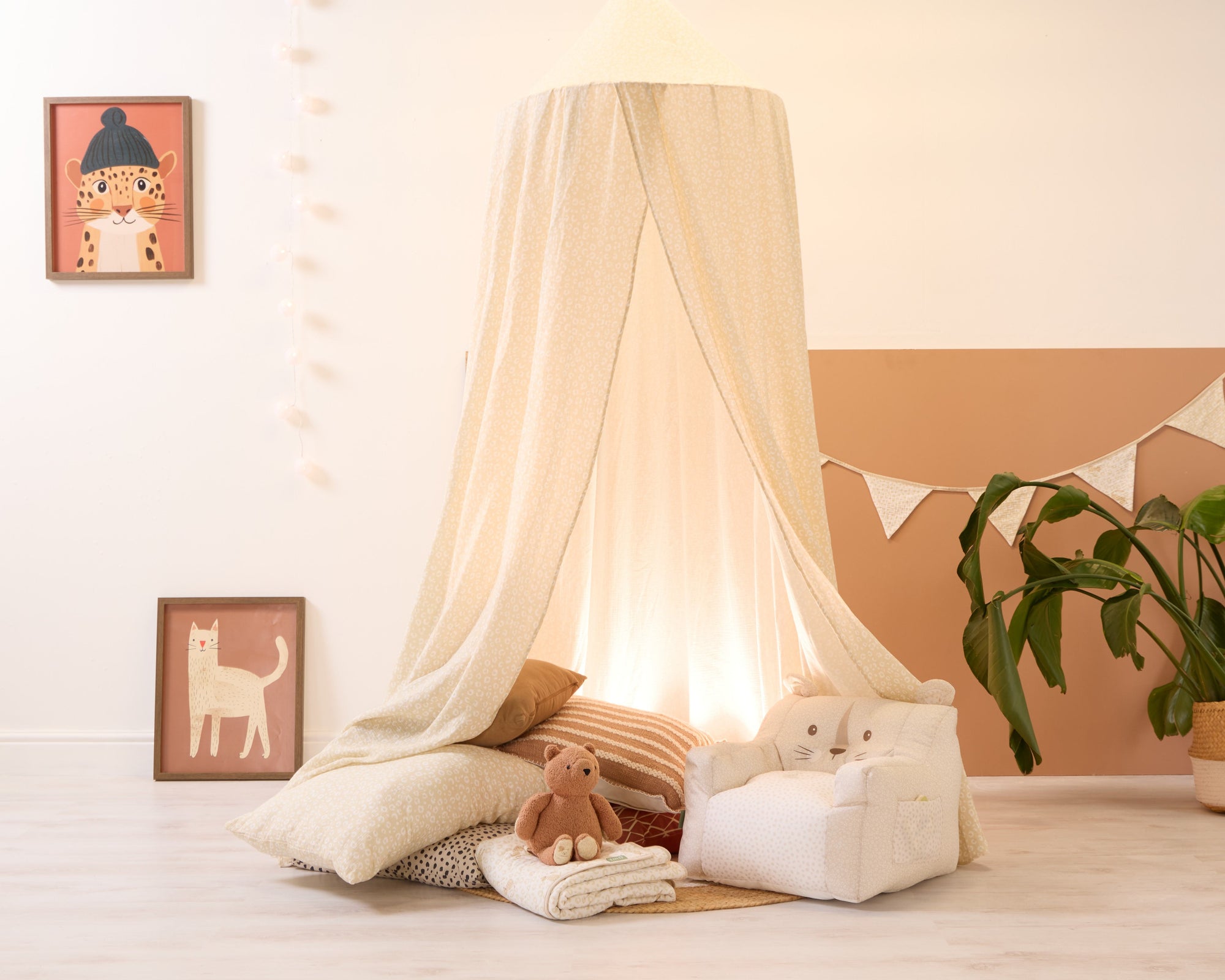 Love Cats nursery canopy styled as a calm corner with layered cushions, cat armchair and framed artwork in warm, earthy hues.