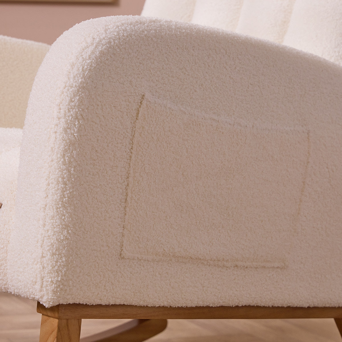 Close-up of a textured chair with a side pocket and wooden legs on a neutral background