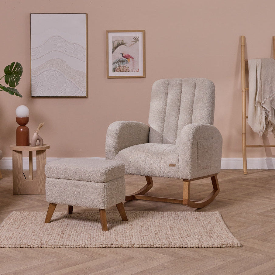 Luca nursing chair in mushroom in a living room with a pink wall, plant, and side table.