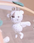 Close-up of spotted Love Cats character toy hanging from wooden play gym arch, crafted in soft muslin fabric.