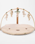 Front view of Love Cats luxury wood muslin play gym featuring curved wooden arch and hanging soft toys.