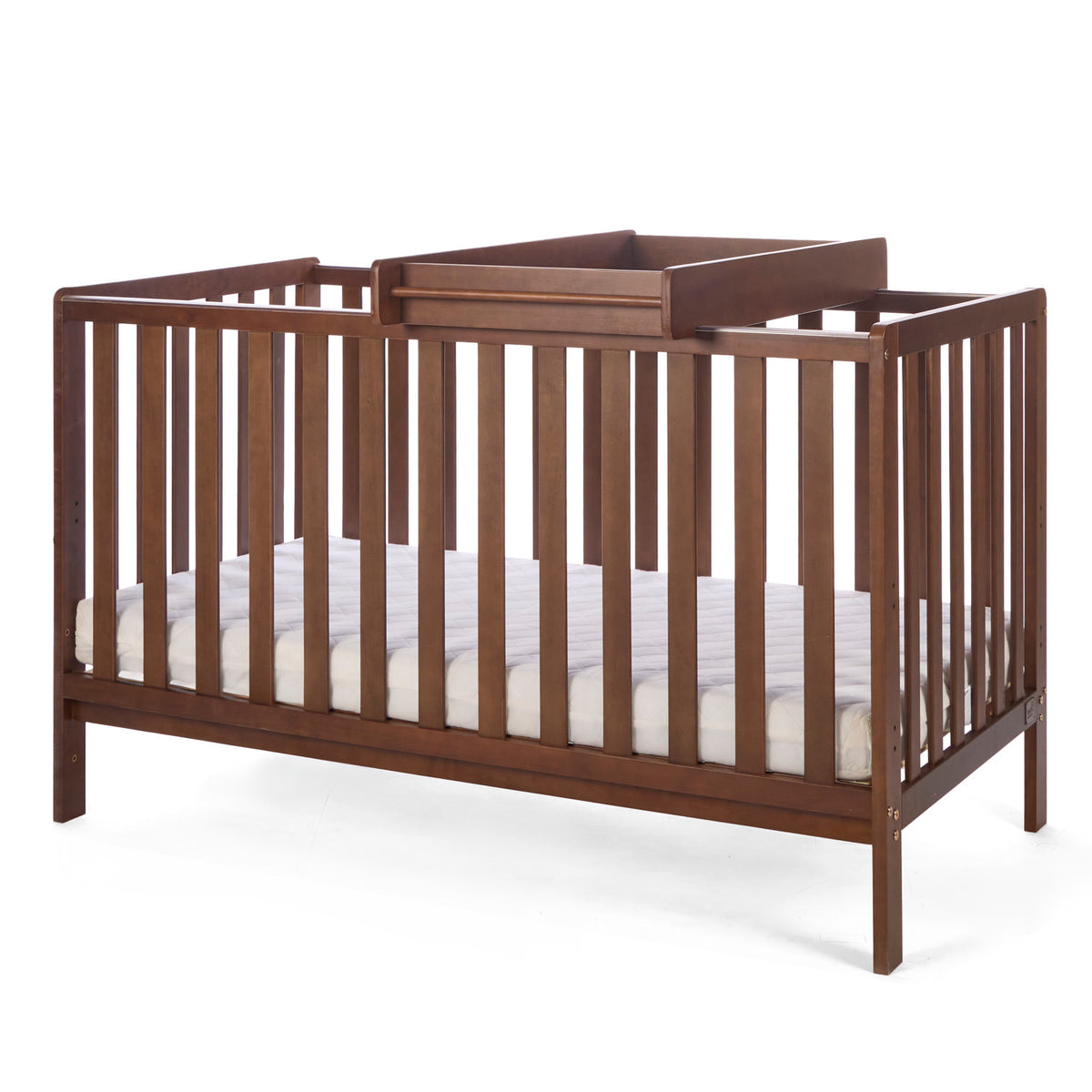 A side view of the Malmo cot bed in rich walnut with a cot top changer and mattress, showing a practical over-cot setup in a white background.