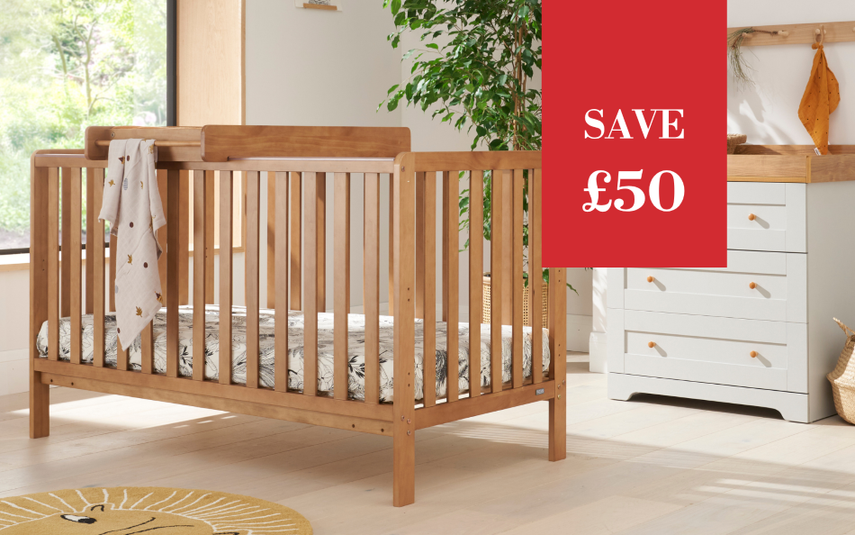 A wooden baby crib with a matching wooden changing tray attached, shown in a bright nursery setting next to a white changing unit. A red promotional overlay on the right reads 'SAVE £50'.