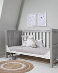 Modena Cot Bed in Grey Ash and White converted into a comfortable sofa bed, showcasing its space-saving functionality and modern design in a serene nursery setting.