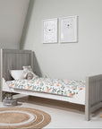 Modena Cot Bed in Grey Ash and White shown in toddler bed mode with woodland-themed bedding, highlighting its adaptability for growing children.