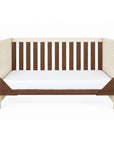 A front view of the Modena cot bed in cashmere and rich walnut converted into a sofa bed, showcasing its versatile 3-in-1 functionality for long-lasting use.