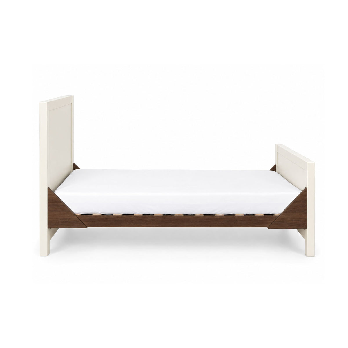 A side view of the Modena cot bed in cashmere and rich walnut in toddler bed mode with the sides removed for easy access and independent sleeping.