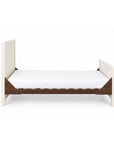 A side view of the Modena cot bed in cashmere and rich walnut in toddler bed mode with the sides removed for easy access and independent sleeping.