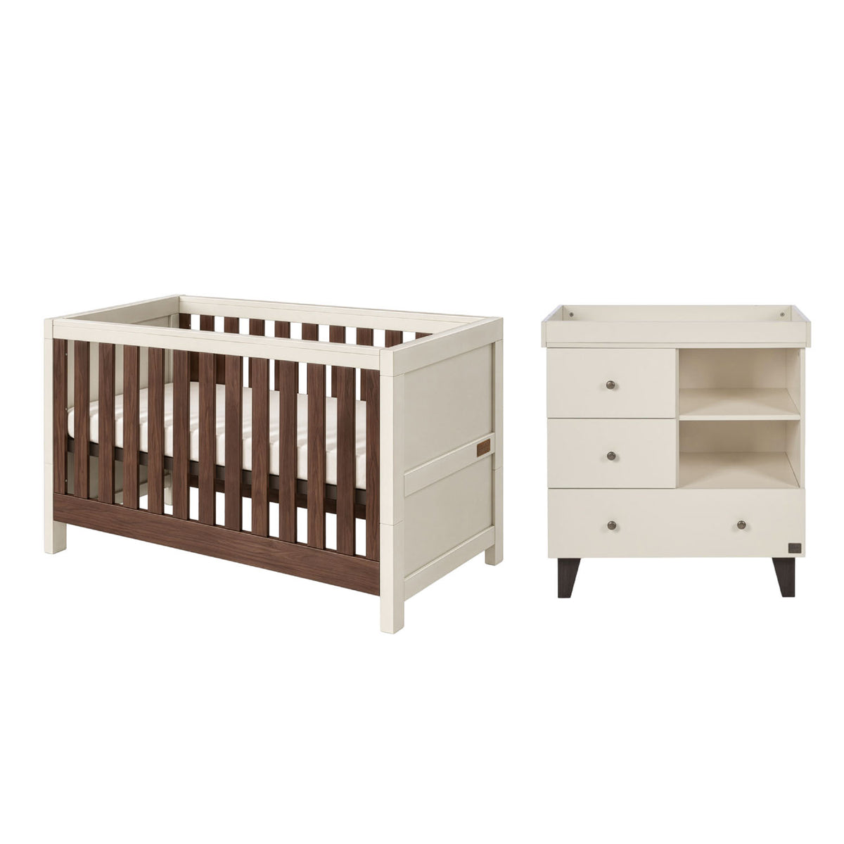 A baby cot bed and changing table with storage set in cream and dark brown wood, shown on a plain white background.