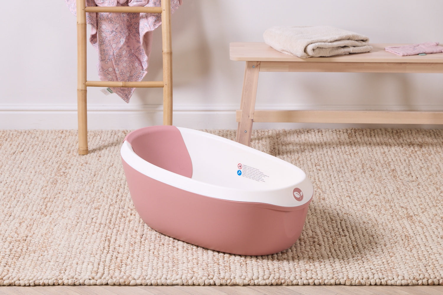 Nati shell baby bath placed on the carpet of a family bathroom.