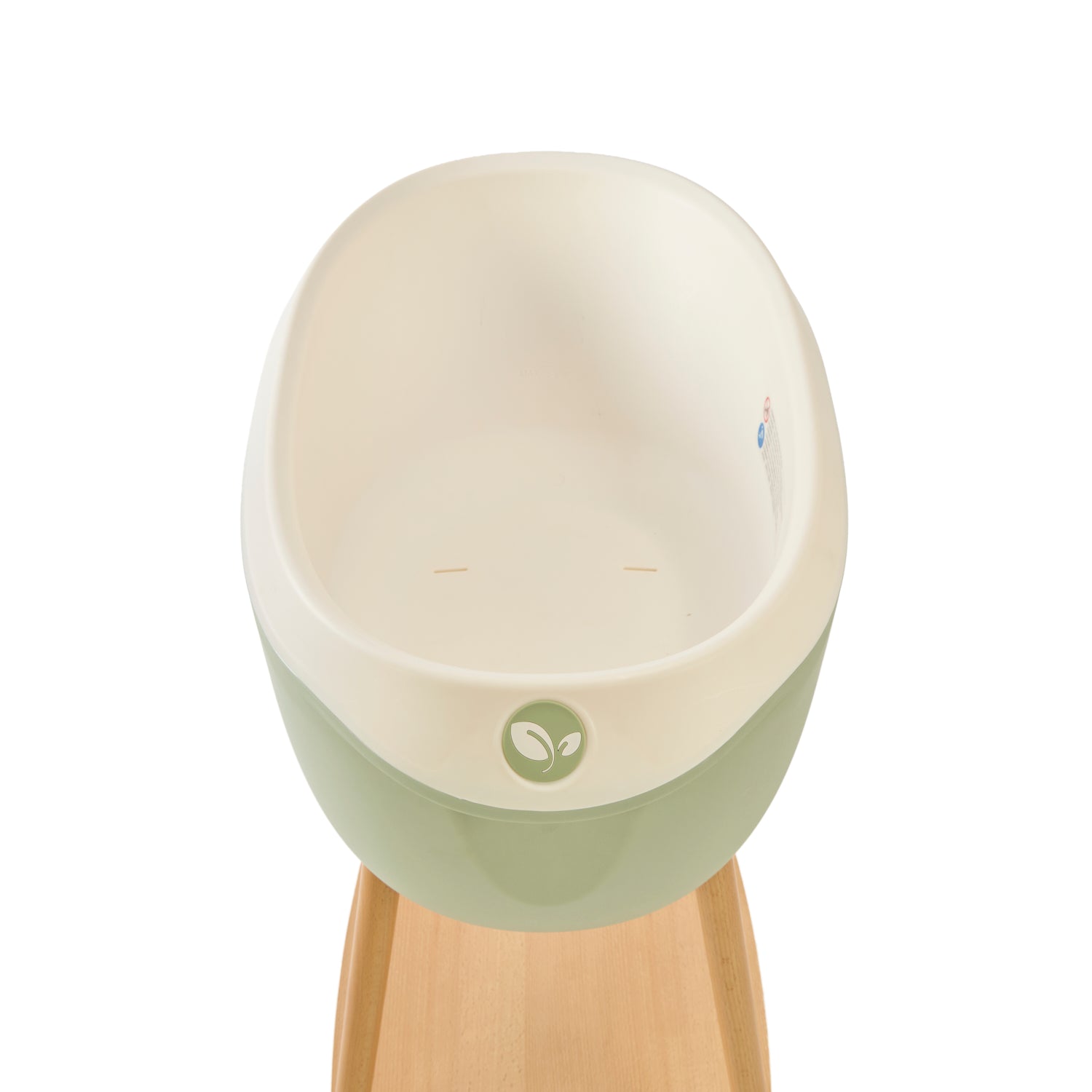 Inside view of the Nati Baby Bath in Green, placed on its wooden stand against a clean white background.