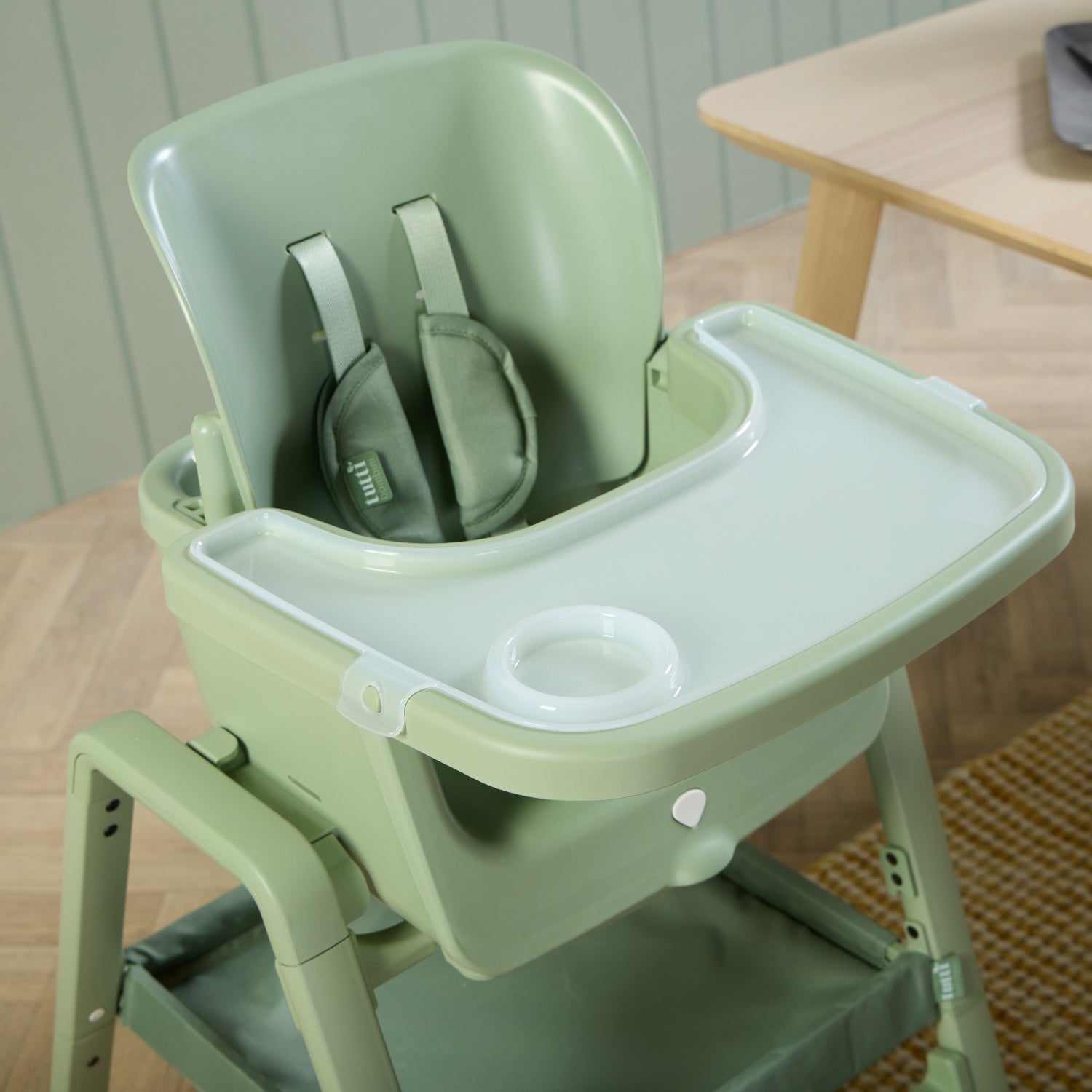 Tray detail of the nova maison 7 in highchair in matcha, showing smooth wipe-clean surface with integrated cup holder for easy feeding.
