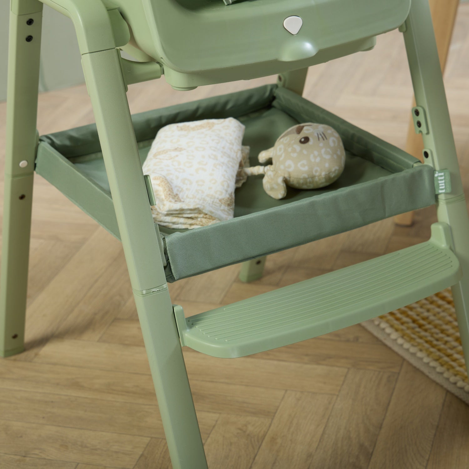 Close-up of the nova maison 7 in highchair in matcha storage tray, offering practical under-seat space for baby essentials and toys.