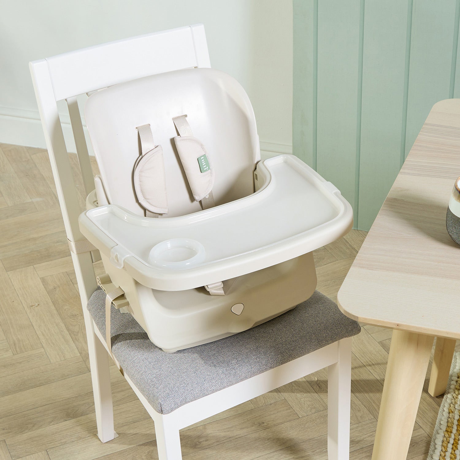 Nova Maison highchair in parnsip used as a booster seat, securely strapped to dining chair with 5-point harness.
