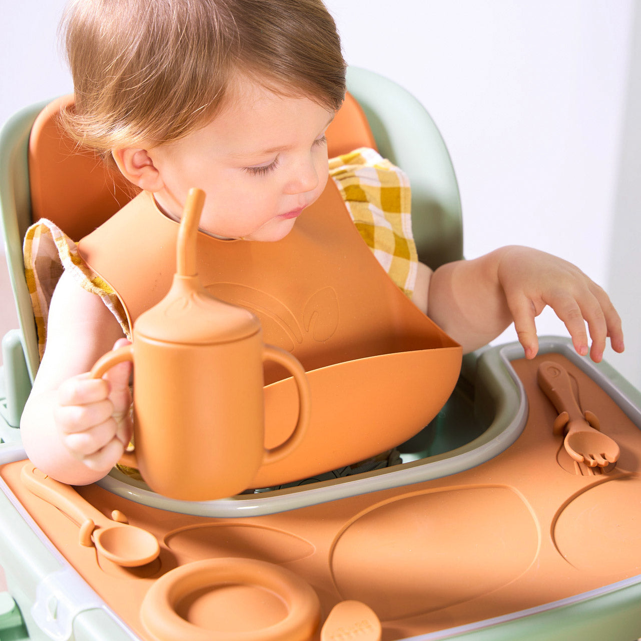A child in a highchair with the Nova accessory pack in orange