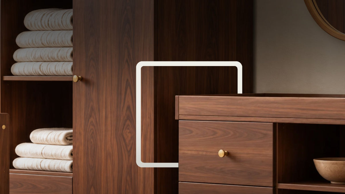 A dark brown wooden nursery furniture set including a changing table with drawers, and a wardrobe with storage shelves, styled with white bedding, a basket, and a round mirror.