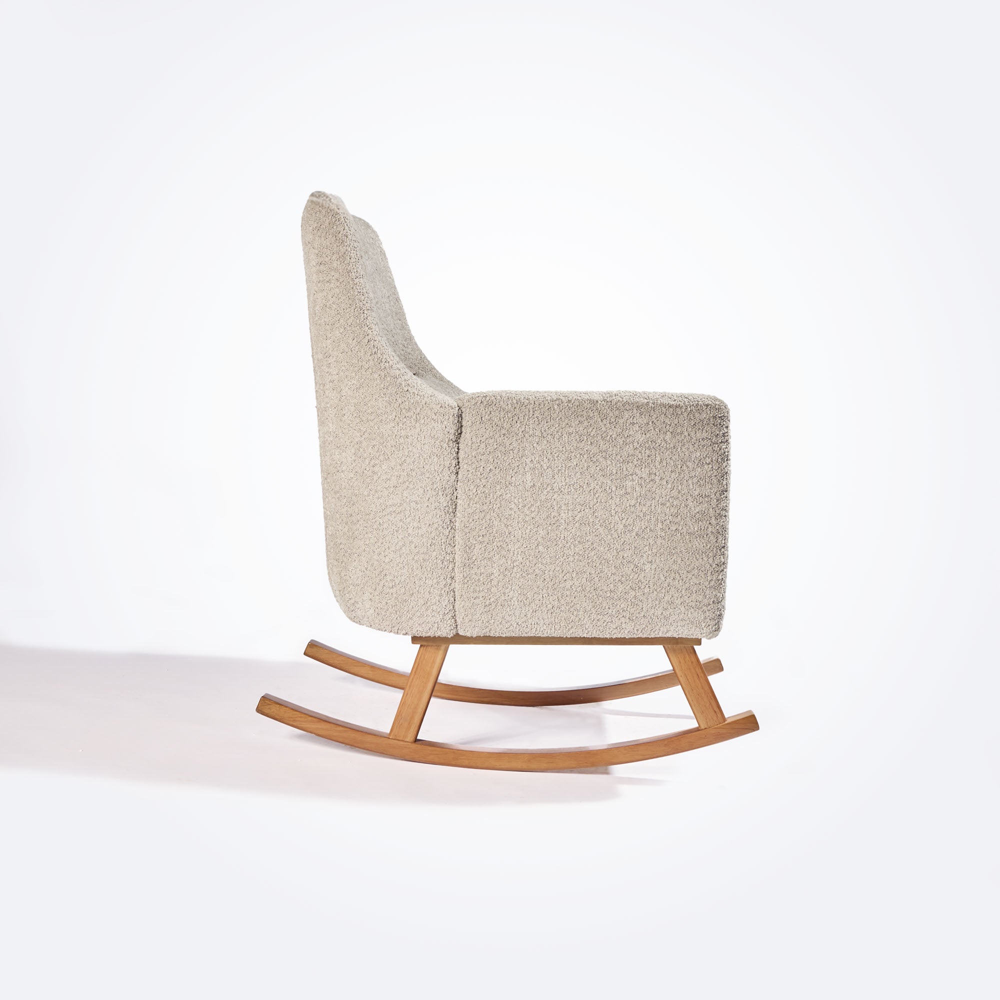 Side cutout of the Oscar Luxe rocking chair in teddy mushroom, showcasing slim profile, padded arms and solid oak rocker legs
