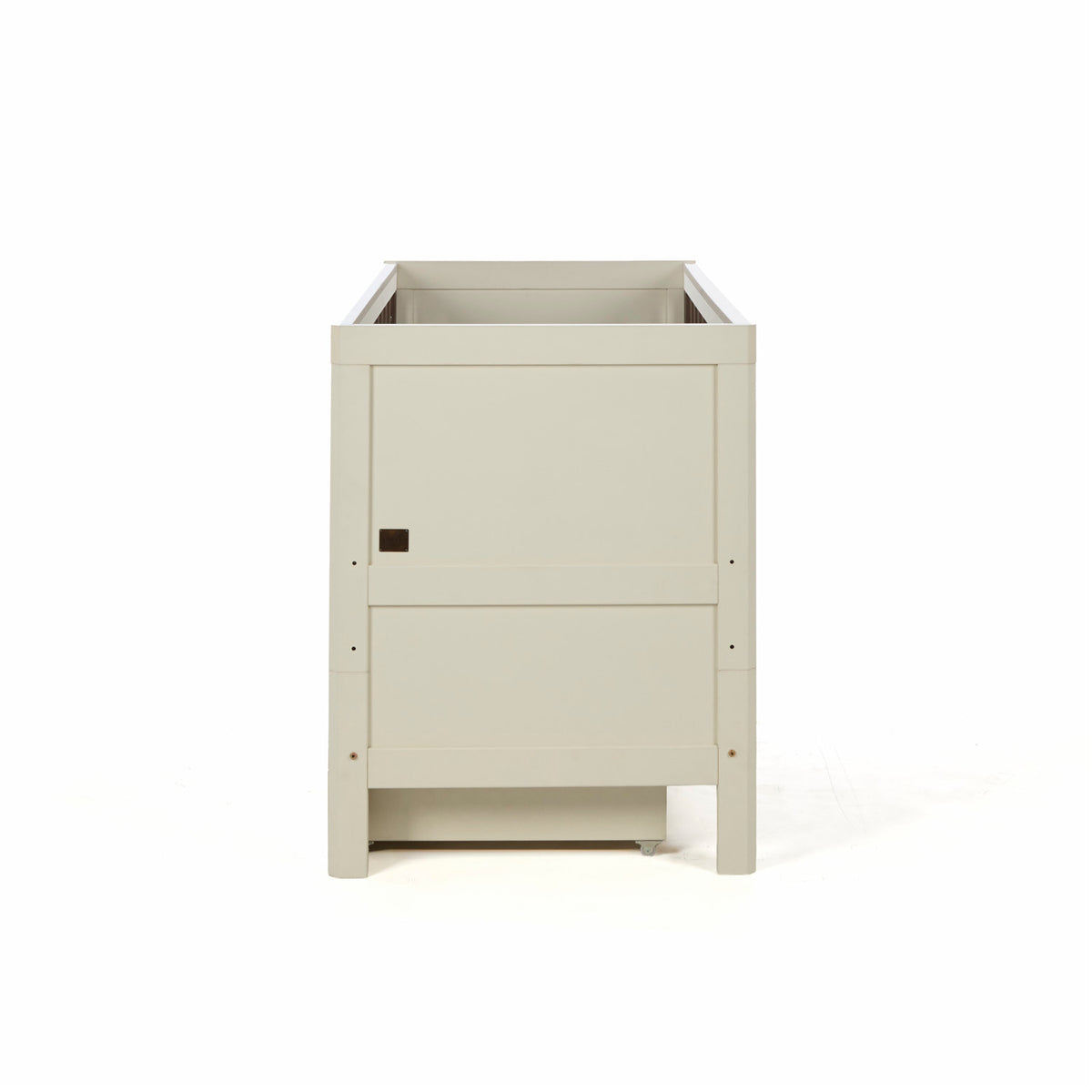 A sideview of the Riley cot bed in cashmere and rich walnut, featuring a drawer beneath it in a white background.