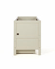 A sideview of the Riley cot bed in cashmere and rich walnut, featuring a drawer beneath it in a white background.
