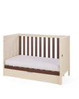 The Riley mIni cot bed in cashmere and rich walnut in sofa mode on a white background.