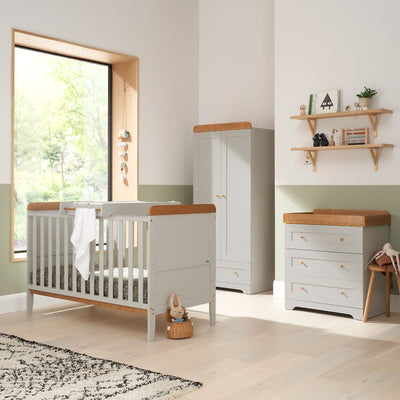 Nursery room view of the Rio three-piece room set in Honey Oak and Dove Grey, including a cot bed with top changer, a spacious wardrobe, and a chest changer for functional storage.
